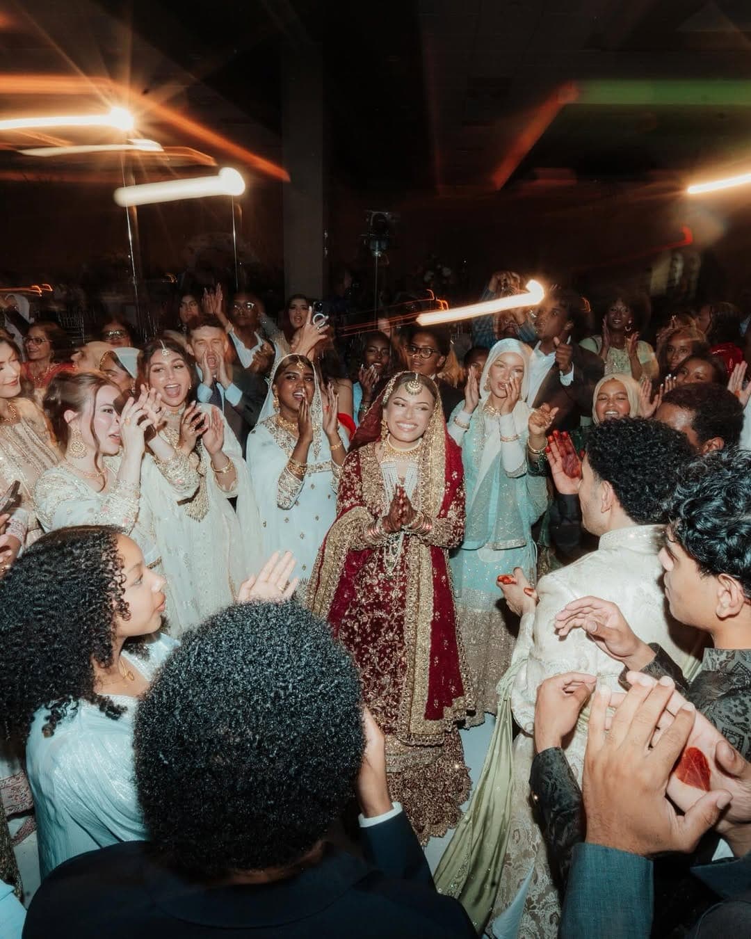 Bride surrounded by a cheering crowd during her grand entrance