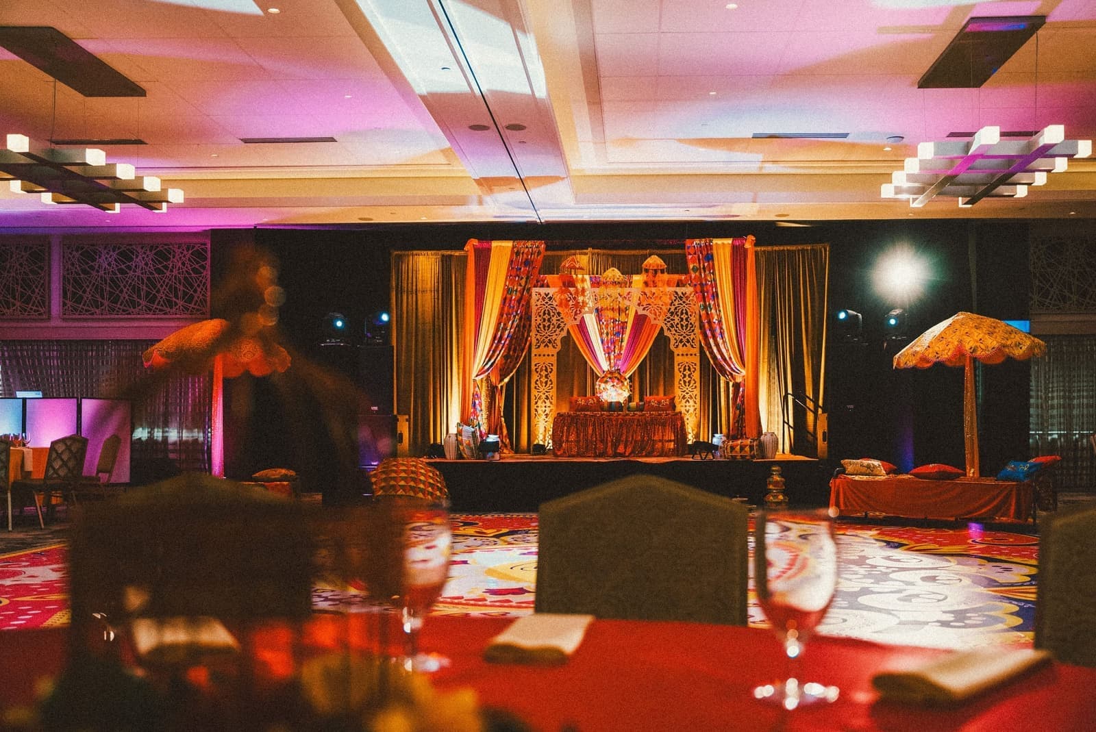 Colorful draped mehndi stage set up for an evening celebration