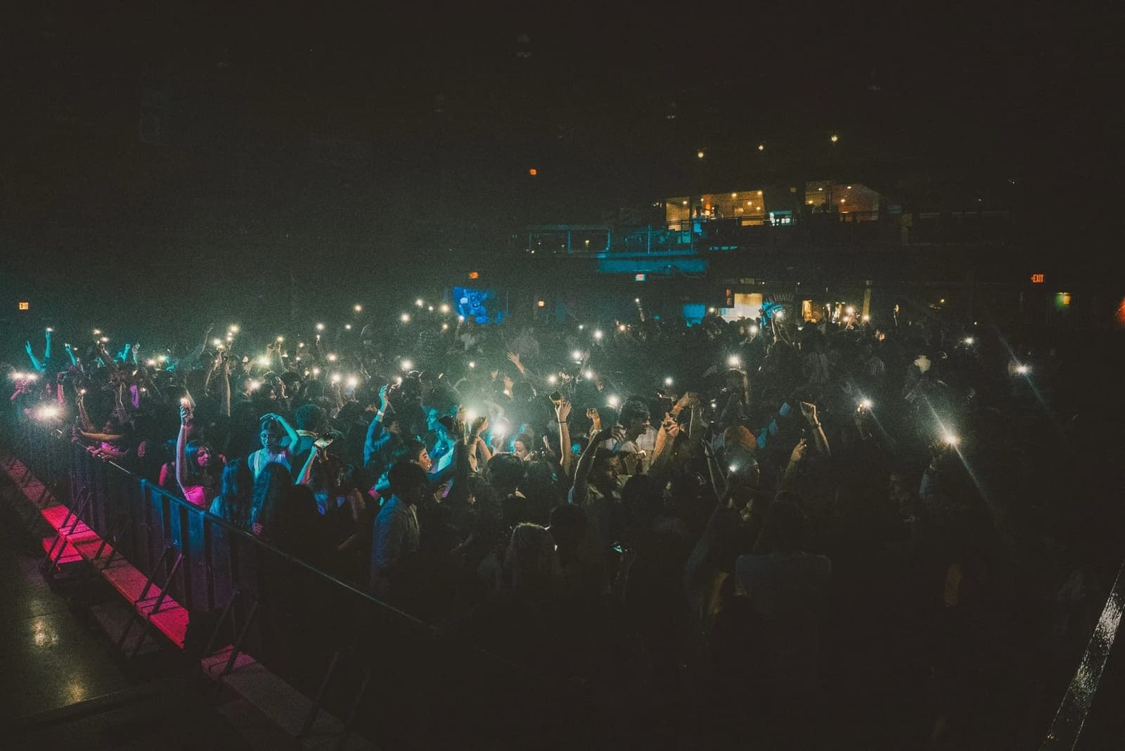 Packed college crowd with phone lights raised at an Amped On Campus event